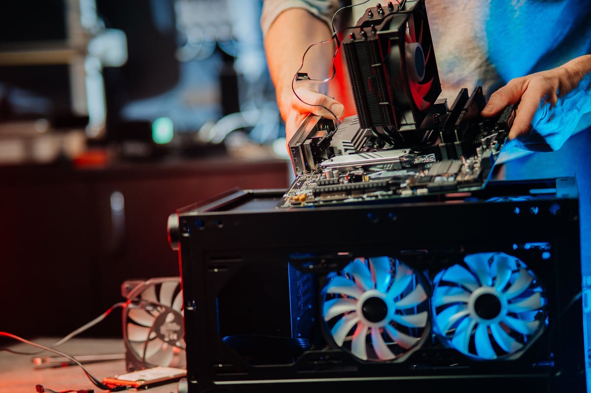 Computer technician installs cooling system of computer. Assembling PC.